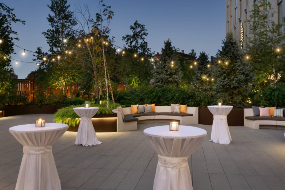 A beautifully decorated banquet space with tables adorned in vibrant floral arrangements and an enchanting overhead display of blossoms.